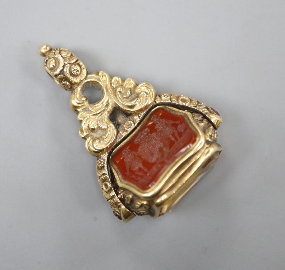 A Victorian yellow metal overlaid swivel triple gem set fob seal, with carved carnelian matrix, 37mm.